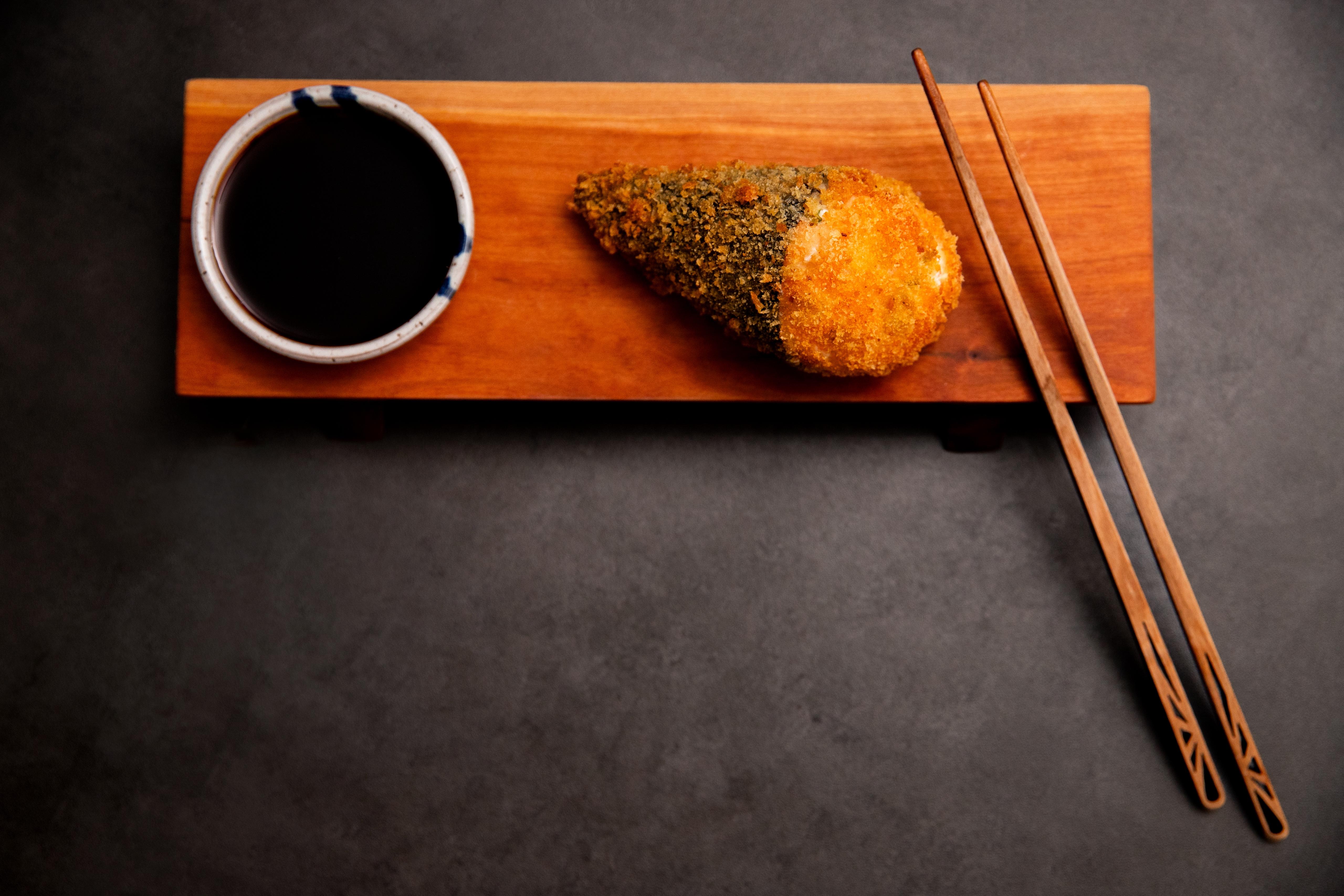 Hot temaki on a wooden board with soy sauce and chopsticks